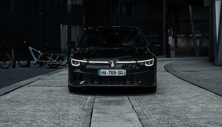 Volkswagen Golf 8 GTI Clubsport noire vue de face, feux allumés